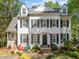 Charming two-story home featuring white siding, black shutters, and a well-manicured front yard and mature trees at 2520 Ashley Ct, Raleigh, NC 27607