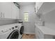 Well-organized laundry room with modern washer and dryer, ample storage cabinets, and a bright window at 2520 Ashley Ct, Raleigh, NC 27607