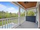 This covered balcony features a stained wood ceiling and overlooks the pool and yard at 255 Seven Island Rd, Pittsboro, NC 27312