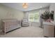 Cozy Bedroom with crib, soft chair, and natural light from the large window at 255 Seven Island Rd, Pittsboro, NC 27312