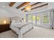 Relaxing main bedroom featuring exposed beams, large windows and French doors to balcony at 255 Seven Island Rd, Pittsboro, NC 27312