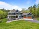 Charming home featuring a covered front porch, a three-car garage, and a well-maintained lawn at 255 Seven Island Rd, Pittsboro, NC 27312