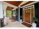 Charming front porch with rocking chairs, natural wood door, and decorative plants for a cozy, inviting entrance at 255 Seven Island Rd, Pittsboro, NC 27312