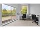 Bright office with built-in desks, large windows, sliding door to the deck, and views of the surrounding trees at 255 Seven Island Rd, Pittsboro, NC 27312