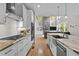 Spacious kitchen open to the living room featuring stainless steel appliances, stone countertops, and hardwood floors at 255 Seven Island Rd, Pittsboro, NC 27312