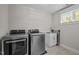 Convenient laundry room equipped with modern washer, dryer, utility sink, and window, simplifying chores at 255 Seven Island Rd, Pittsboro, NC 27312