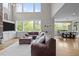Spacious living room featuring a cozy sectional sofa, white rug, and large windows with scenic views at 255 Seven Island Rd, Pittsboro, NC 27312