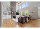 Bright living room with hardwood floors, a stone fireplace, built-in shelves, and large windows with scenic views at 255 Seven Island Rd, Pittsboro, NC 27312