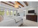 Bright main bedroom boasts wood beam ceiling, fireplace, balcony and ensuite bath access at 255 Seven Island Rd, Pittsboro, NC 27312