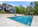 Gorgeous in-ground pool with travertine surround, water features, and an upper level patio with walk out stairs at 255 Seven Island Rd, Pittsboro, NC 27312