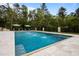 Stunning in-ground pool featuring water features, travertine surround, and an umbrella stand with lounging furniture at 255 Seven Island Rd, Pittsboro, NC 27312