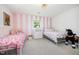 Stylish bedroom featuring pink and white striped walls, two twin beds, and coordinated decor for a playful atmosphere at 2960 Epps Clark Rd, Siler City, NC 27344