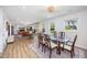 Open concept dining room with a glass table, modern lighting, and seamless transition to the living room at 2960 Epps Clark Rd, Siler City, NC 27344