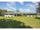 Inviting single-story brick home featuring a lush lawn and charming rocking chairs on the front porch at 2960 Epps Clark Rd, Siler City, NC 27344