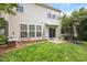 Backyard with green lawn, patio, sliding glass doors, and lush landscaping at 308 Apricot Cir, Morrisville, NC 27560