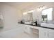 Bright bathroom featuring double sinks, a soaking tub, granite counters and decorative light fixtures at 308 Apricot Cir, Morrisville, NC 27560