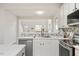 Modern kitchen with stainless steel appliances, white cabinets, tile backsplash and view into the living area at 308 Apricot Cir, Morrisville, NC 27560