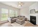 Bright living room with large sectional couch, fireplace and many windows overlooking the backyard at 308 Apricot Cir, Morrisville, NC 27560