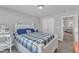 Bright bedroom with a white wood bed frame and blue and green plaid patterned bedding and white nightstand at 350 Stephens Way, Youngsville, NC 27596