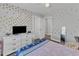 Bedroom with gold polka dot accent wall, white dresser, and bed with patterned covers at 350 Stephens Way, Youngsville, NC 27596