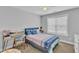 Neutral toned bedroom featuring a window, blue bed with patterned covers, desk, and ceiling fan at 350 Stephens Way, Youngsville, NC 27596