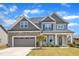 Charming two-story home featuring a stone facade, gray siding, and a well-manicured lawn at 350 Stephens Way, Youngsville, NC 27596