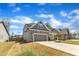 Attractive home with gray siding, stone accents, and a driveway, surrounded by well-maintained landscaping at 350 Stephens Way, Youngsville, NC 27596