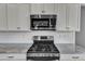 Well-equipped kitchen featuring stainless steel appliances and granite countertops with white cabinets at 350 Stephens Way, Youngsville, NC 27596