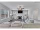 Bright living room featuring a fireplace, ceiling fan, large windows, and comfortable couches at 350 Stephens Way, Youngsville, NC 27596