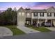 Charming townhome featuring a two-car garage, well-maintained lawn, and welcoming curb appeal at dusk at 3735 Landshire View Ln, Raleigh, NC 27616