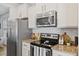This is a close up of the bright kitchen featuring stainless steel appliances and granite countertops at 3735 Landshire View Ln, Raleigh, NC 27616