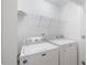 Laundry room with side-by-side washer and dryer, overhead wire shelving, and painted white walls at 3735 Landshire View Ln, Raleigh, NC 27616