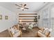Bright living room featuring a modern design with neutral paint, wood accent wall, and many windows at 3735 Landshire View Ln, Raleigh, NC 27616