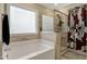 Well-lit bathroom featuring a soaking tub and glass shower, tile surround, and skull shower curtain at 375 Alcock Ln, Youngsville, NC 27596