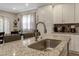Close up of a kitchen island with stainless sink, granite countertop and a view of dining room at 375 Alcock Ln, Youngsville, NC 27596