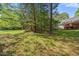 Wooded backyard with mature trees and a red deck, perfect for entertaining and enjoying outdoor living at 378 E Raleigh Ave, Liberty, NC 27298