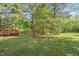 Large, wooded backyard with deck and mature trees offering privacy and shade for outdoor enjoyment at 378 E Raleigh Ave, Liberty, NC 27298