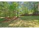 Expansive backyard featuring mature trees and a lush green lawn, perfect for outdoor activities at 378 E Raleigh Ave, Liberty, NC 27298