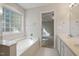 Bright bathroom featuring a soaking tub, vanity with sink and view to bedroom at 378 E Raleigh Ave, Liberty, NC 27298