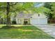Home featuring a well-manicured lawn, mature trees, an attached two-car garage, and a front entrance at 378 E Raleigh Ave, Liberty, NC 27298