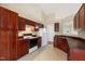 Traditional kitchen with dark wood cabinetry, black appliances, and tiled flooring at 378 E Raleigh Ave, Liberty, NC 27298