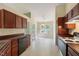 Kitchen with wood cabinets, black appliances, tile flooring, and a door to the backyard at 378 E Raleigh Ave, Liberty, NC 27298