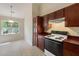 Bright kitchen area with wooden cabinets and standard appliances, adjacent to a dining area at 378 E Raleigh Ave, Liberty, NC 27298