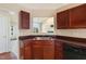 Kitchen featuring wood cabinetry and a double basin sink, with views into the living area at 378 E Raleigh Ave, Liberty, NC 27298