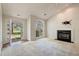 Bright living room featuring a fireplace, large windows, and an open doorway to the outside at 378 E Raleigh Ave, Liberty, NC 27298