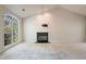 Bright living room featuring large windows, a ceiling fan, a fireplace, and neutral carpeting at 378 E Raleigh Ave, Liberty, NC 27298