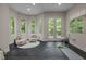 Bright exercise room featuring black rubber flooring, large windows, and French doors opening to a balcony with wooded views at 417 Swans Mill Xing, Raleigh, NC 27614