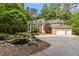 Expansive brick home with a circular driveway, lush landscaping, and serene pond at 417 Swans Mill Xing, Raleigh, NC 27614