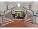 Grand foyer with dual curved staircases, elegant chandelier, and views to the living room at 417 Swans Mill Xing, Raleigh, NC 27614