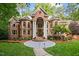 Stately brick home featuring a grand entrance with white columns and manicured landscaping at 417 Swans Mill Xing, Raleigh, NC 27614